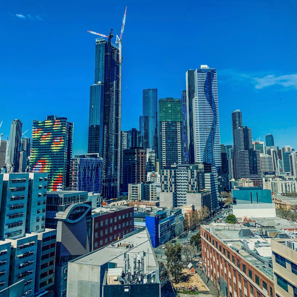 Captivating view of Melbourne's modern skyline under a bright blue sky, featuring iconic skyscrapers.